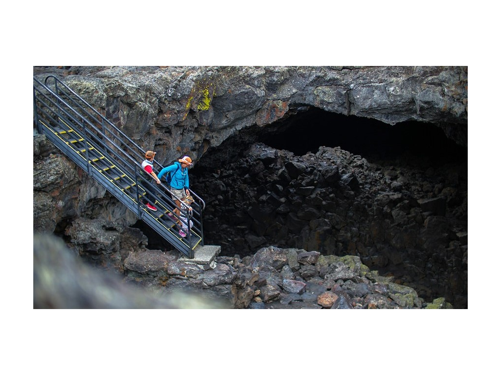 Pyke family descending down metal stairs into cave in Craters of the Moon National Monument