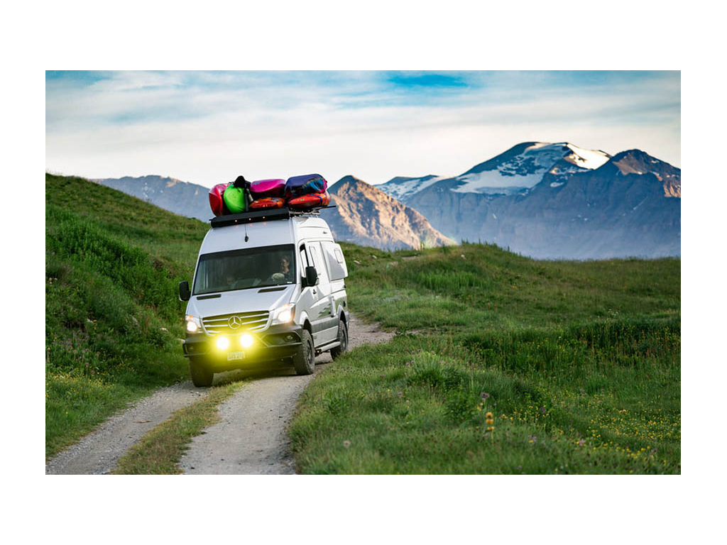Revel driving off-road in French Alps with kayaks on top