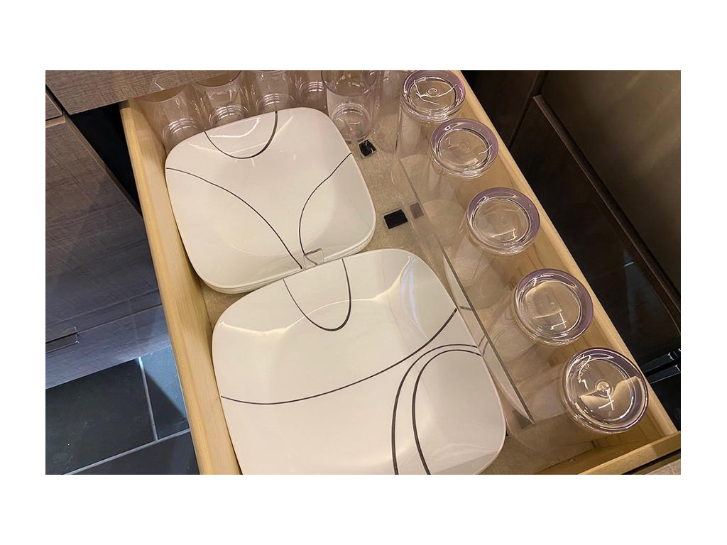 Organized drawer of drinking glasses and white plates
