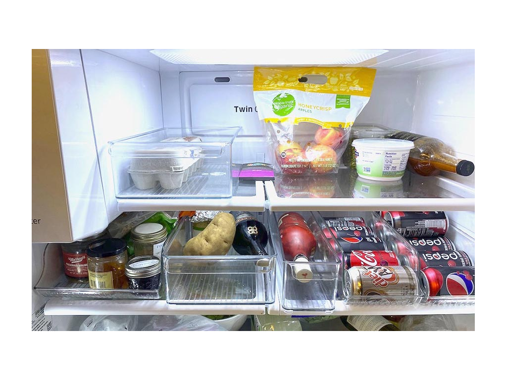 Refrigerator with dividers full of food and drinks