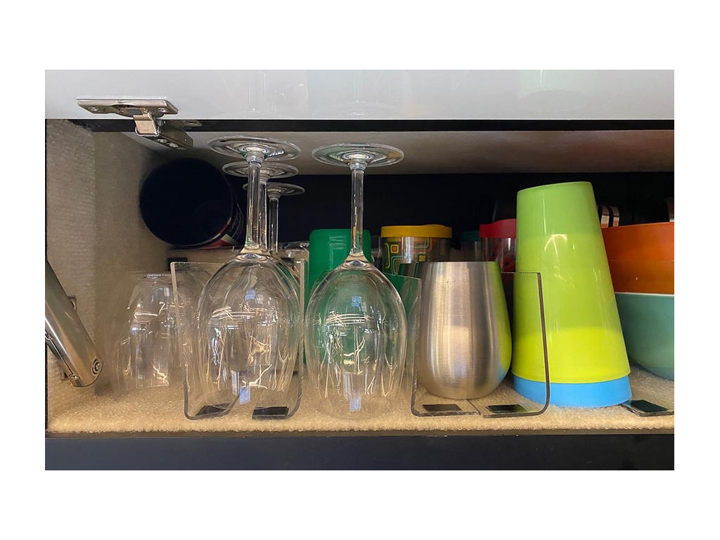 A cabinet full of cups and drinking glasses sitting between dividers
