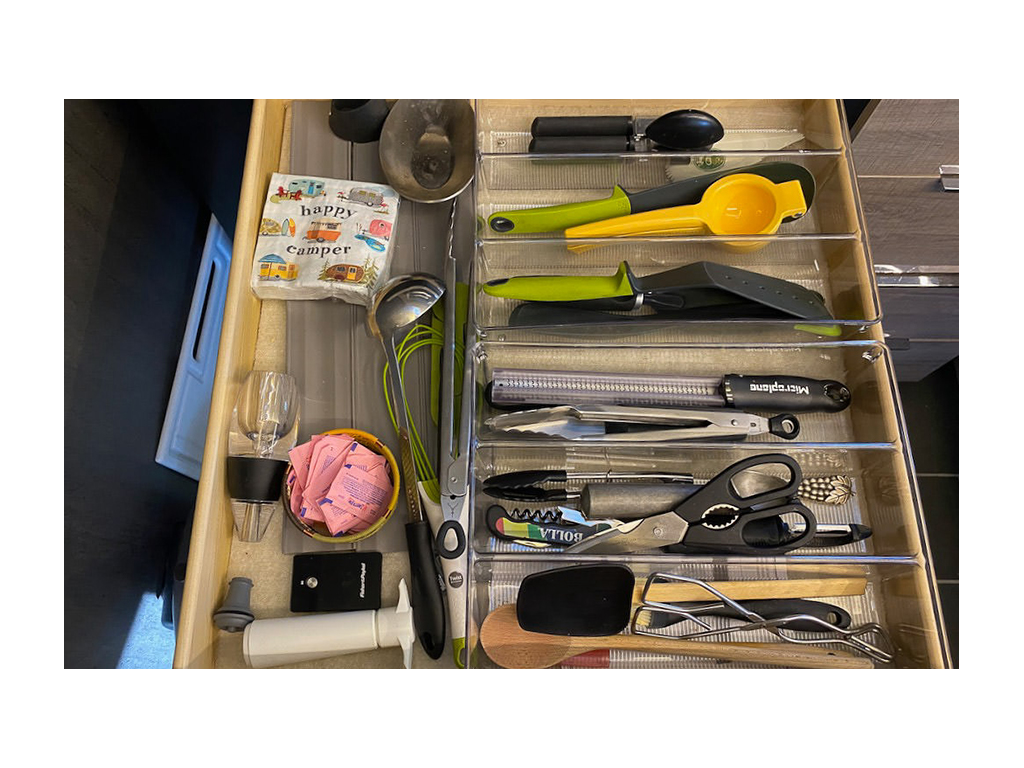 Drawer of kitchen utensils organised using divider