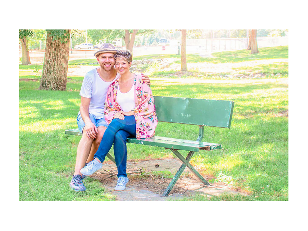 Nic and Jess sitting on a bench at a park