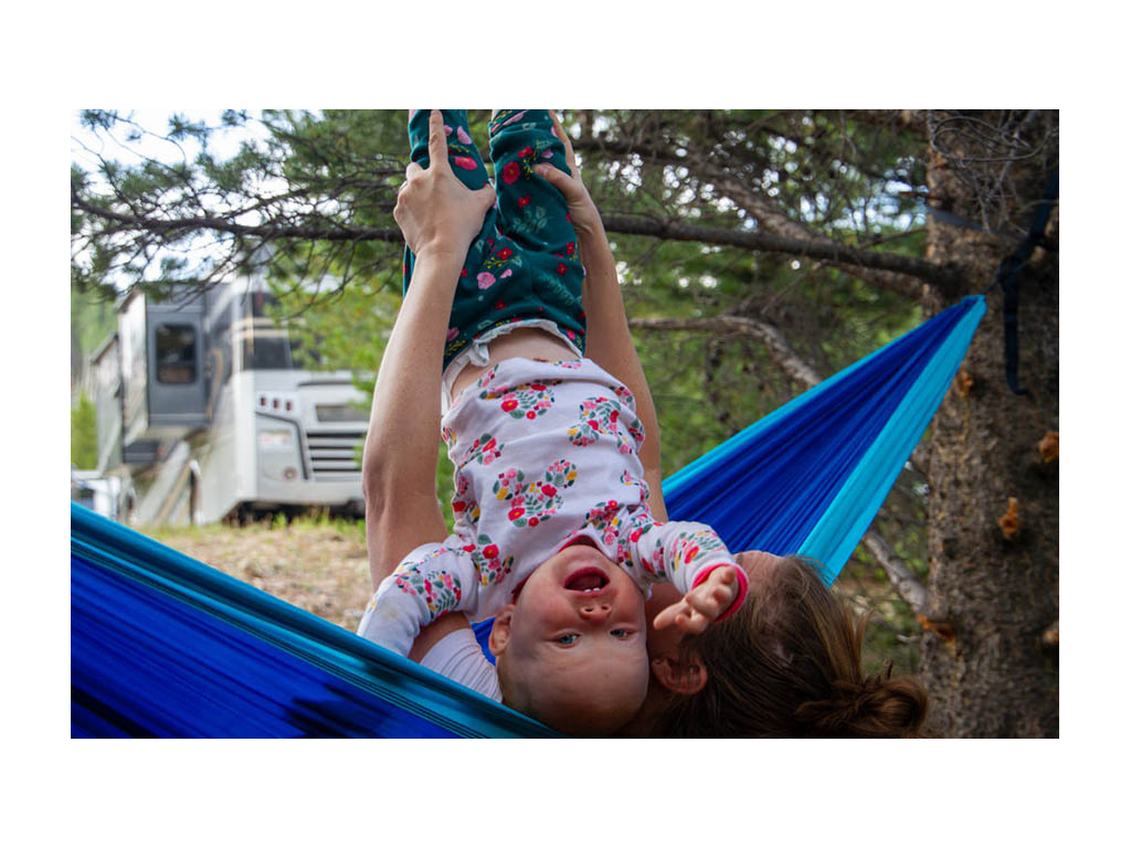 Alyssa holding Ellie upside down in hammock