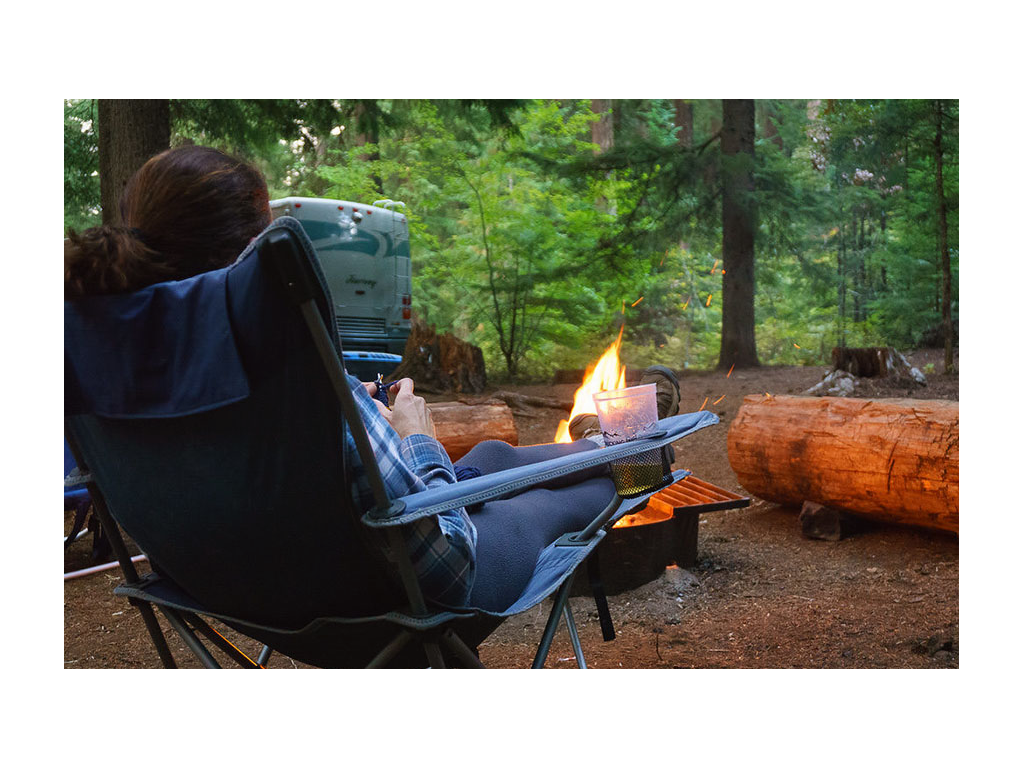 Jaime sitting in chair near campfire