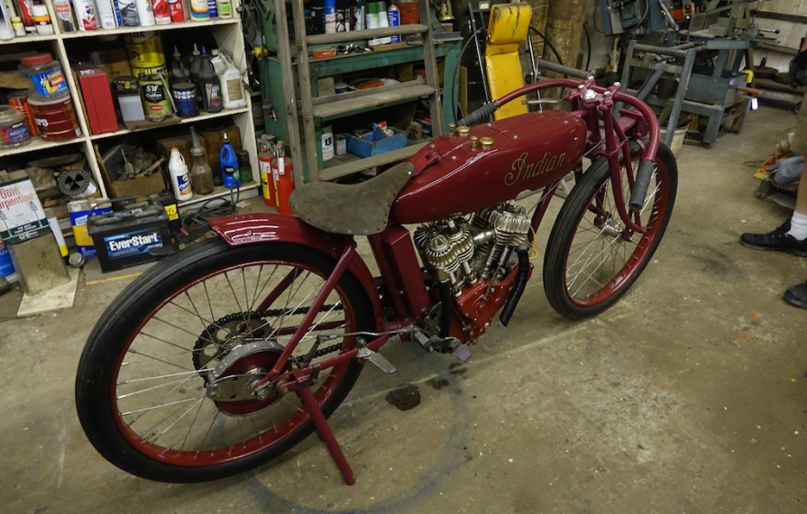 Old red Indian Motorcycle in a workshop.