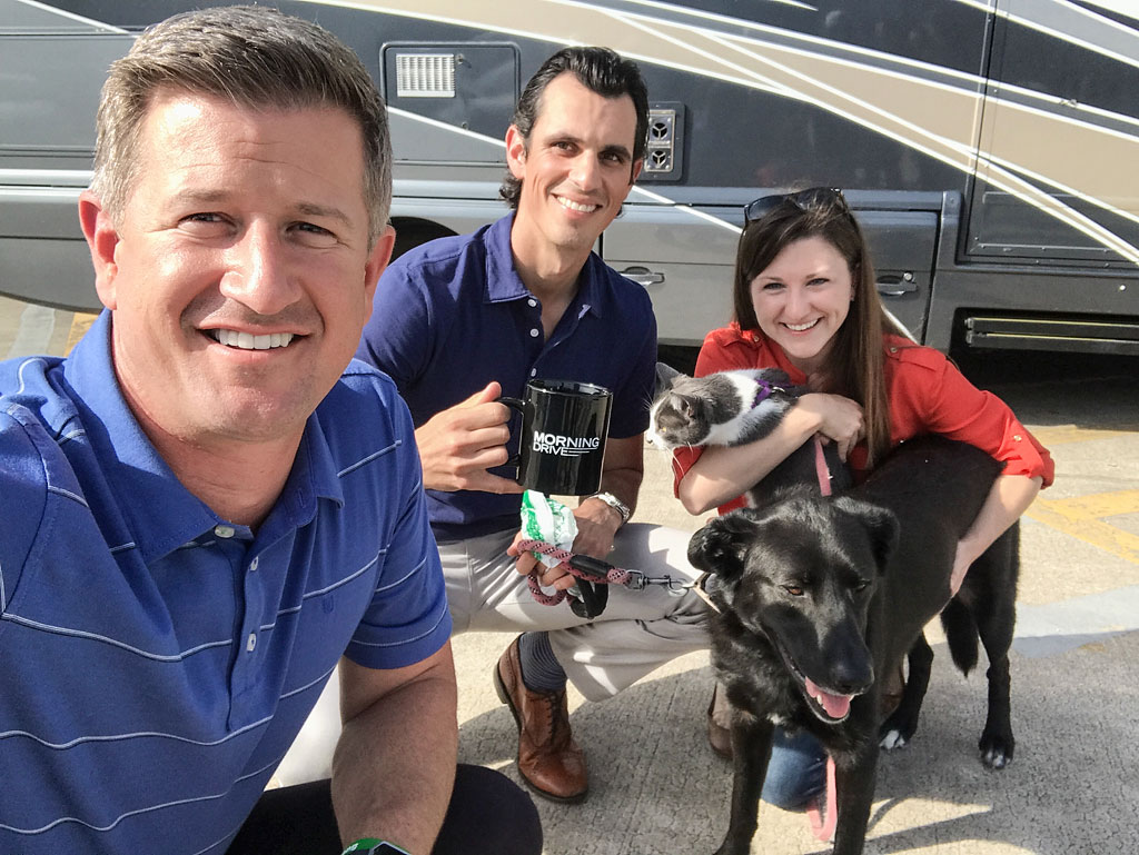 Jordan, Brittany and their dog and cat with Matt Ginella taking a selfie in front of their Winnebago View.