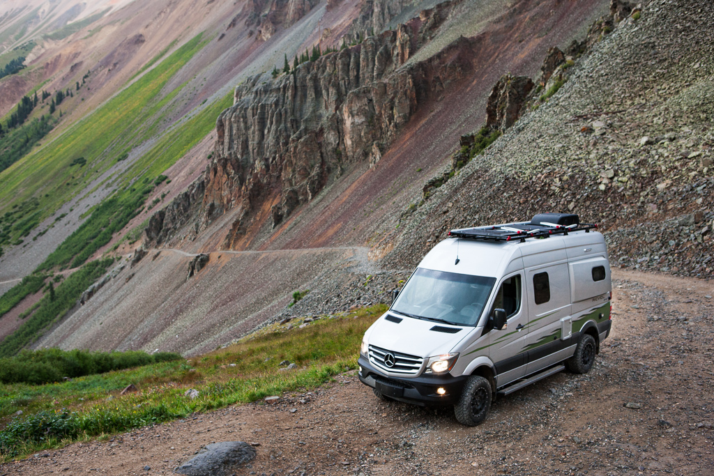 Winnebago Revel parked at the start of an extremely narrow trail along the steep hillside.