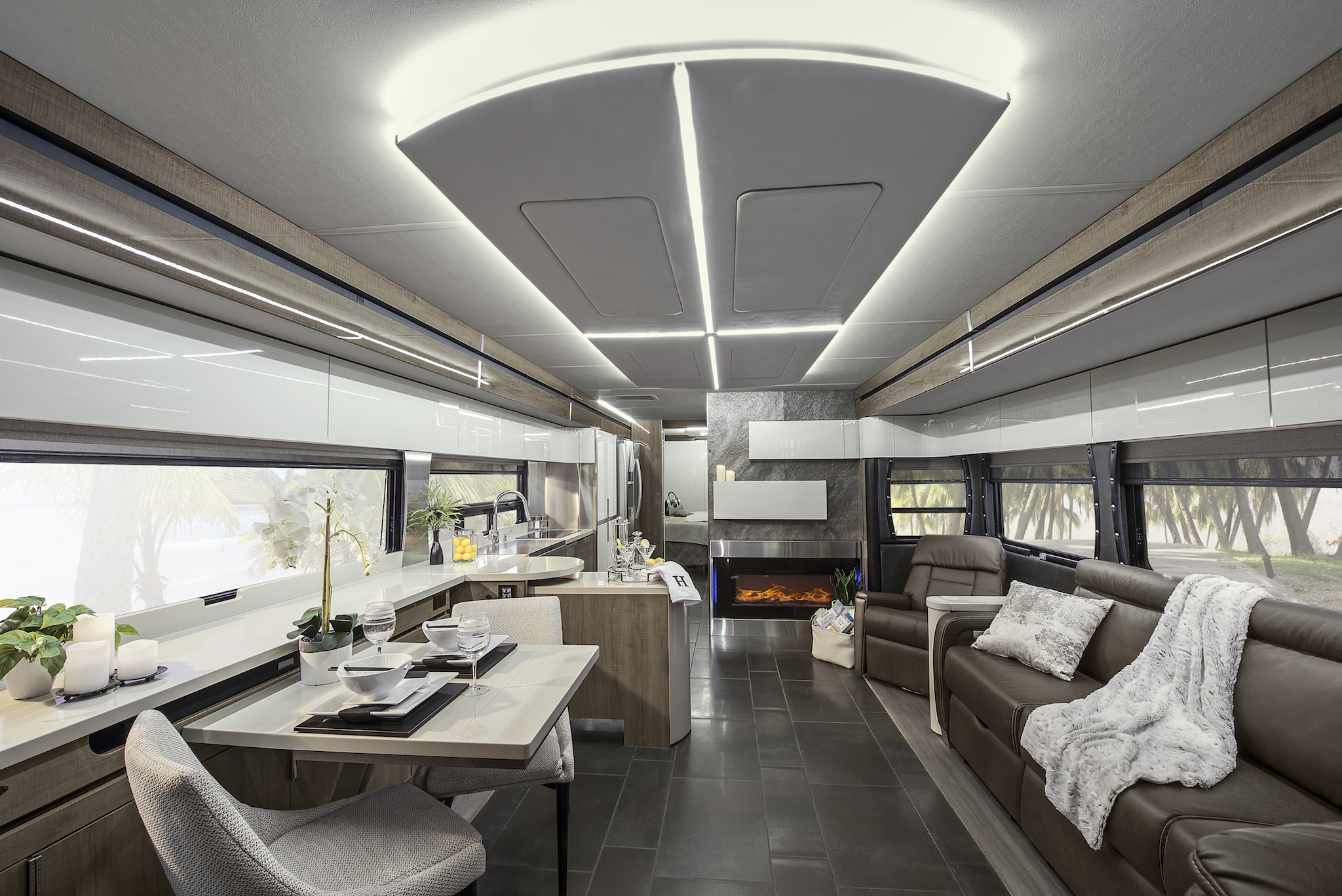 Modern interior of Winnebago Horizon with backlit LED lights on ceiling panel that brighten the space.