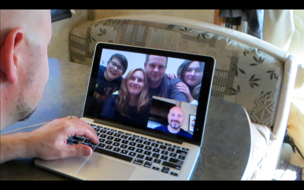 Kenny video chatting family on computer