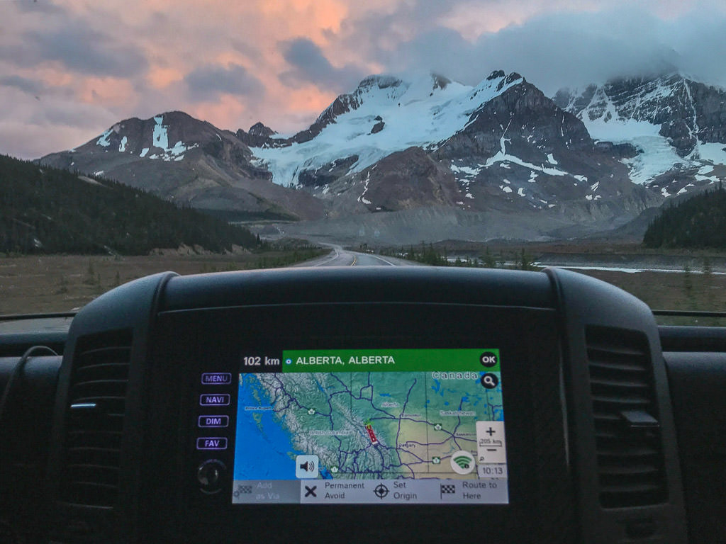 GPS on the RV dash showing Alberta, Alberta with view of mountains out the front windshield
