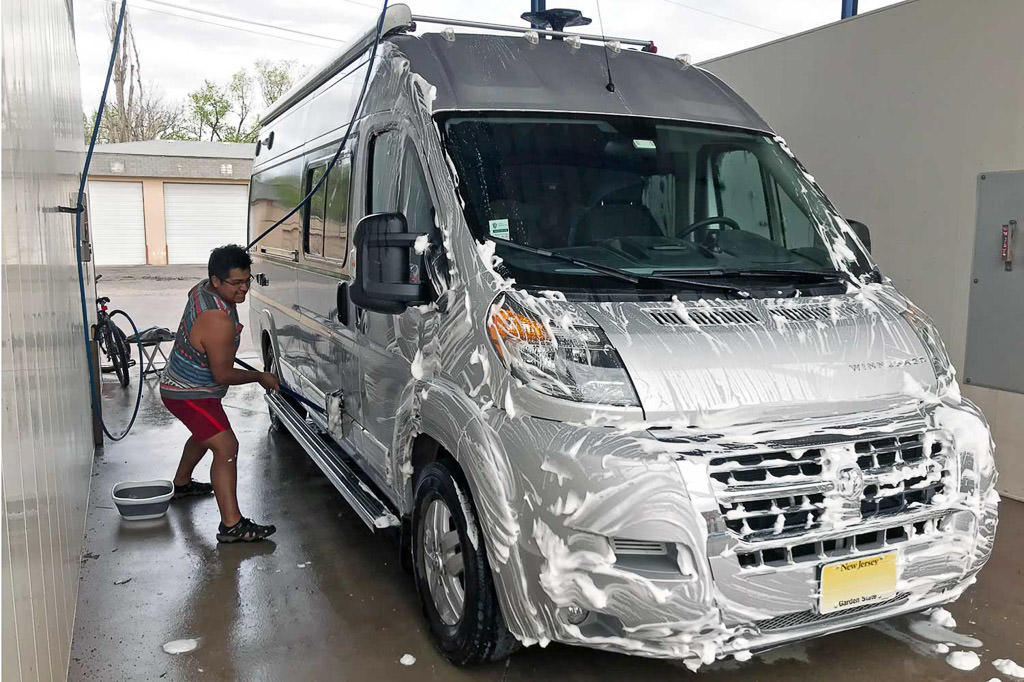 Humberto scrubbing exterior of van at car wash
