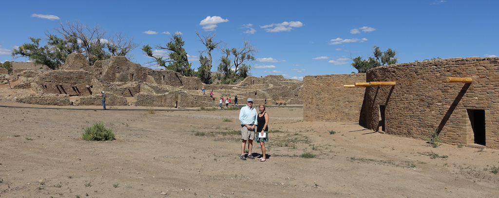Wider view of Don and his wife standing in front of the ruins his parents were 70 years prior.