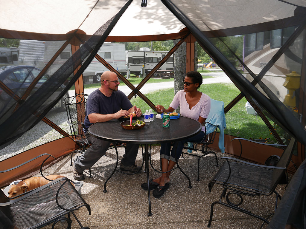 Couple enjoying a meal in their Clam Quick-set escape gazebo
