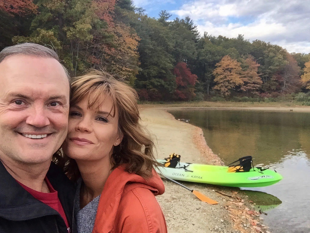 Susan and Bill taking a selfie in front of a lake
