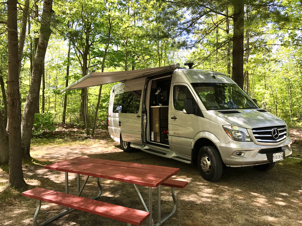 Era parked in campsite with sliding door open and awning out