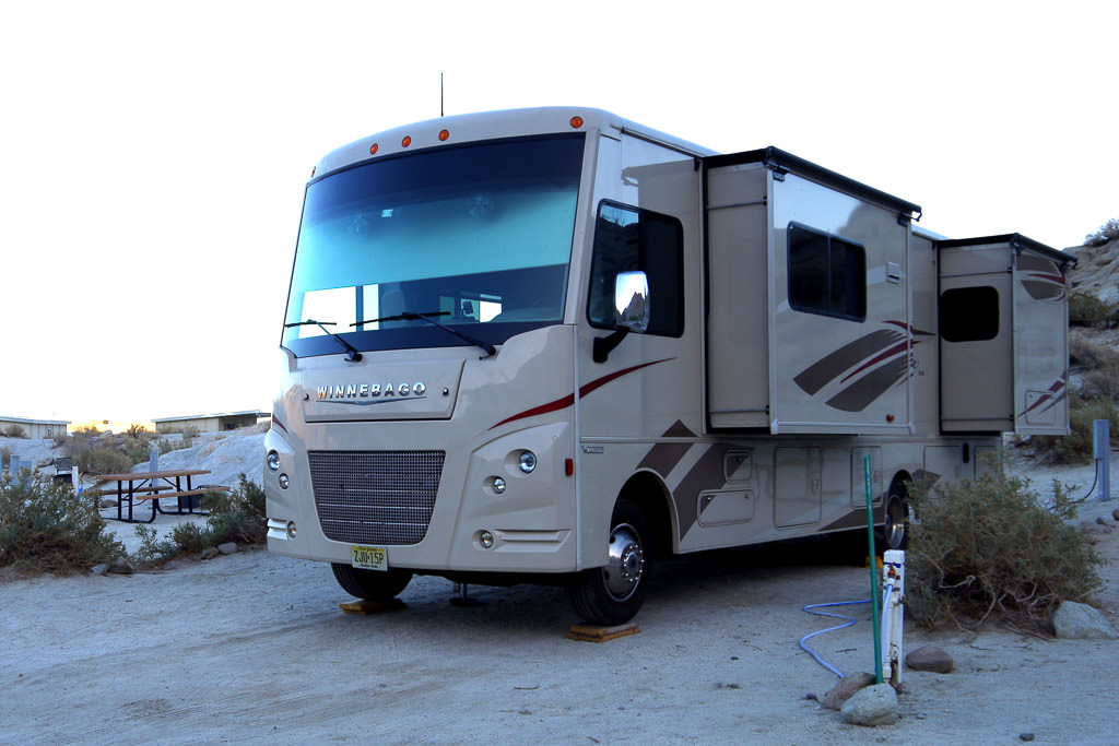 Winnebago Sunstar parked with slide outs out in campsite.
