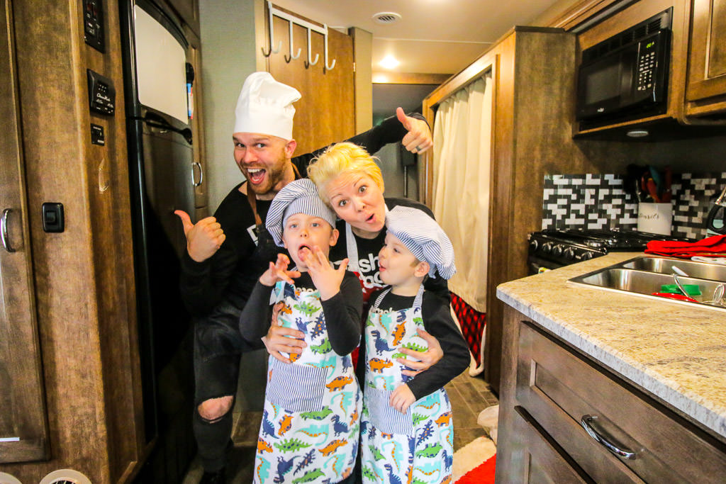 Young family posing for silly picture in the Galley of their RV