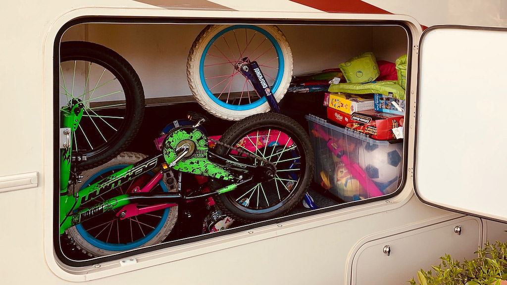 Bikes and games in outside storage compartment of the Winnebago Vista.