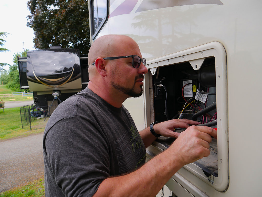 A man evaluating electrical components of his Winnebago Vista