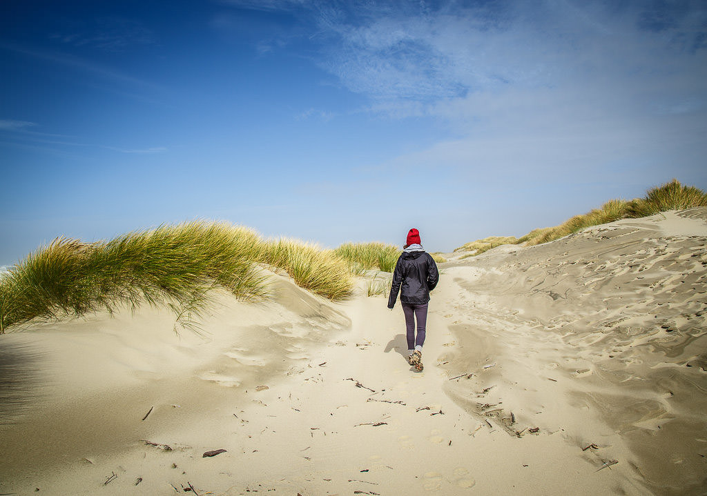 Woman walking along the sand dunes