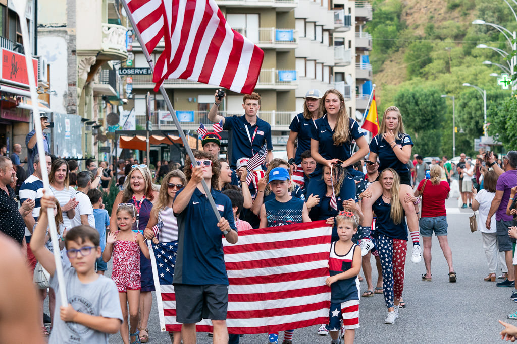 Group of people with American flags marching in parade.